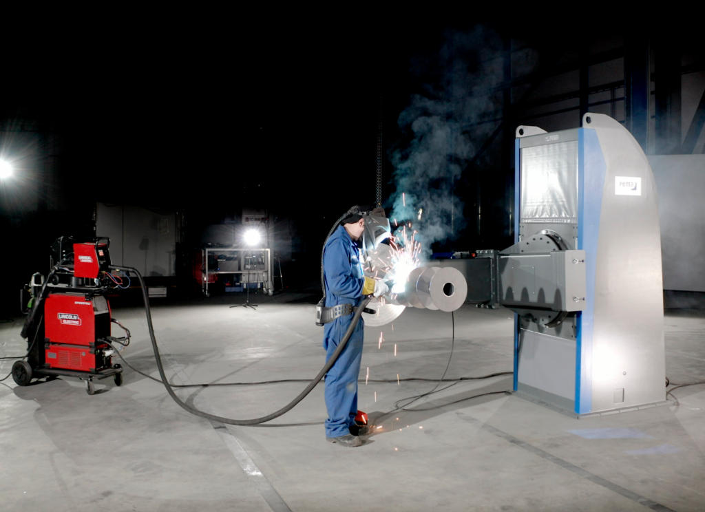 Industrial welding positioner rotating a cylindrical workpiece for precision welding in manufacturing.