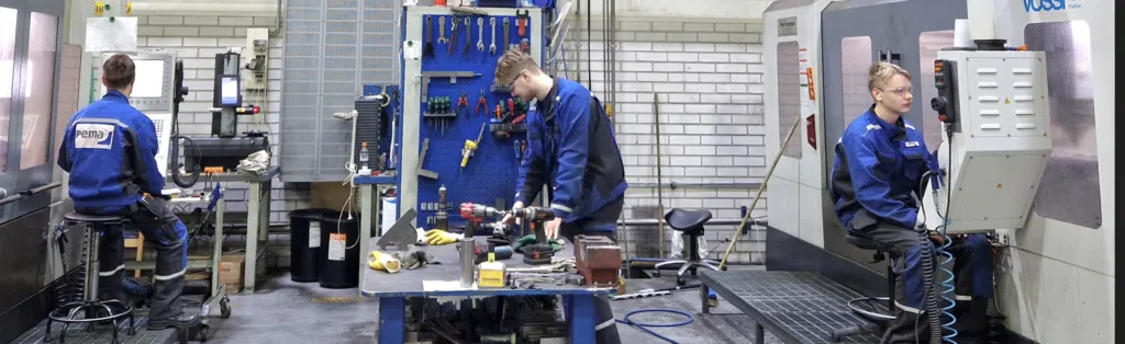 Kuva Pemamekin koneistamossa. Kuvassa näkyy kolme ihmistä työssään.